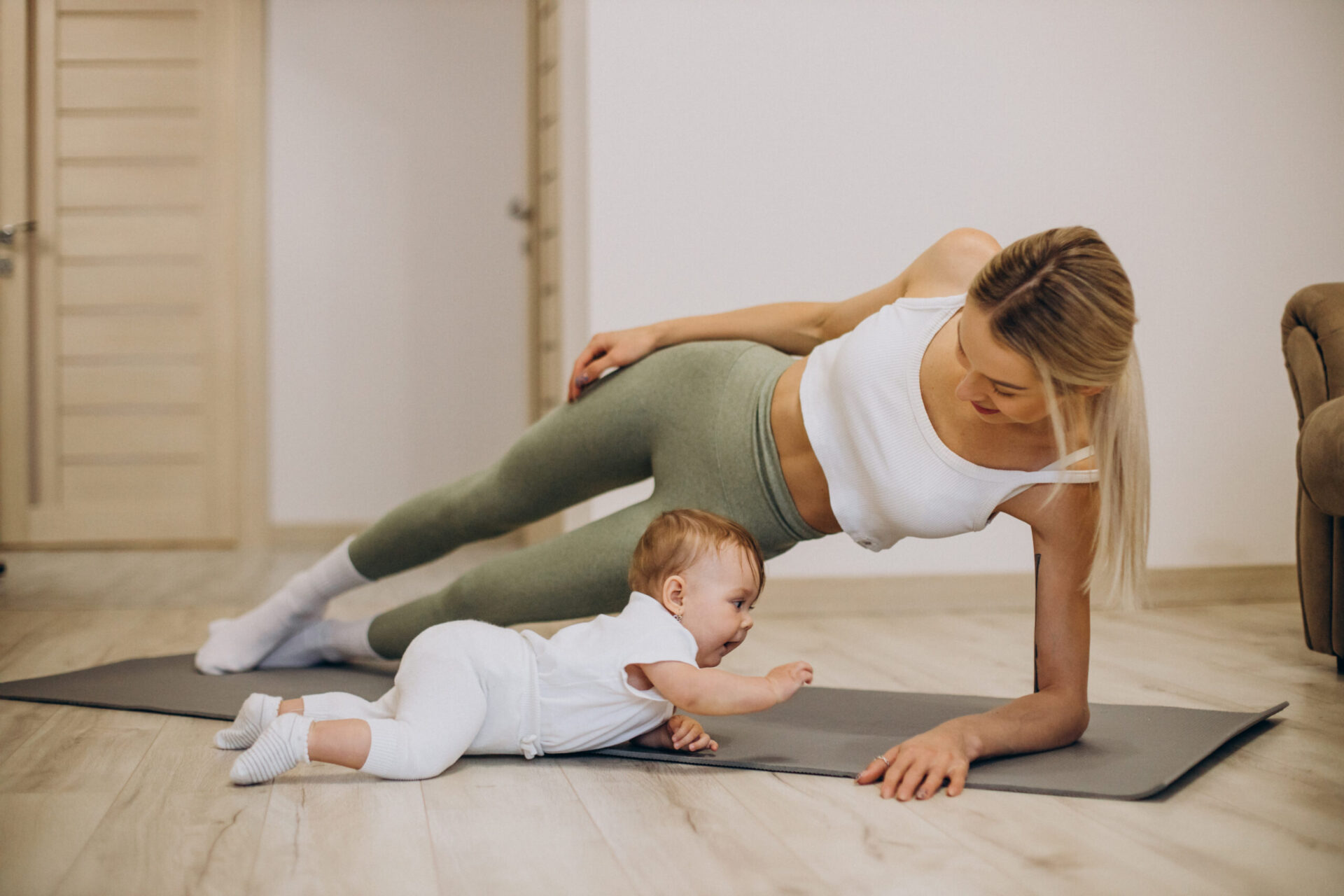 Home mother practicing yoga with her baby daughter at home