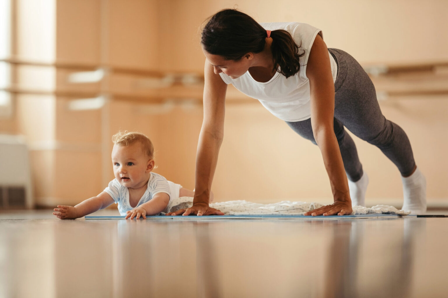 Hebamme Herrsching Helma Bock-Pilates 2 Frau über Baby beim Gymnastik und Pilatesübungen
